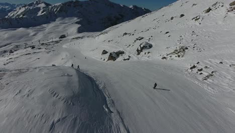 Aerial-shot-following-a-skier-skiing-down-a-mountain-in-the-French-Alps